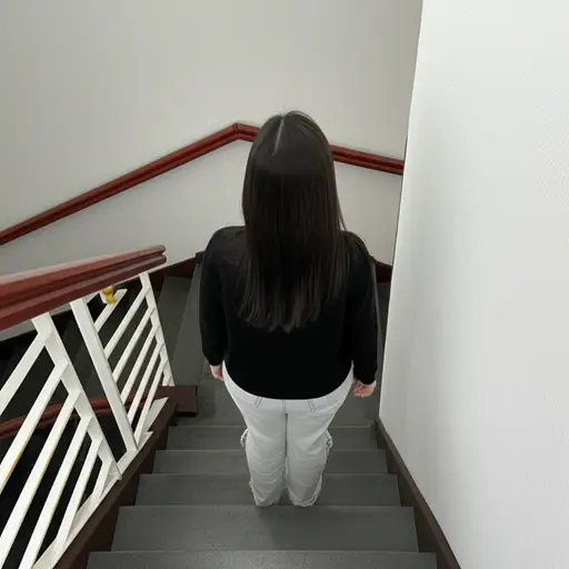 她站在楼梯顶部。