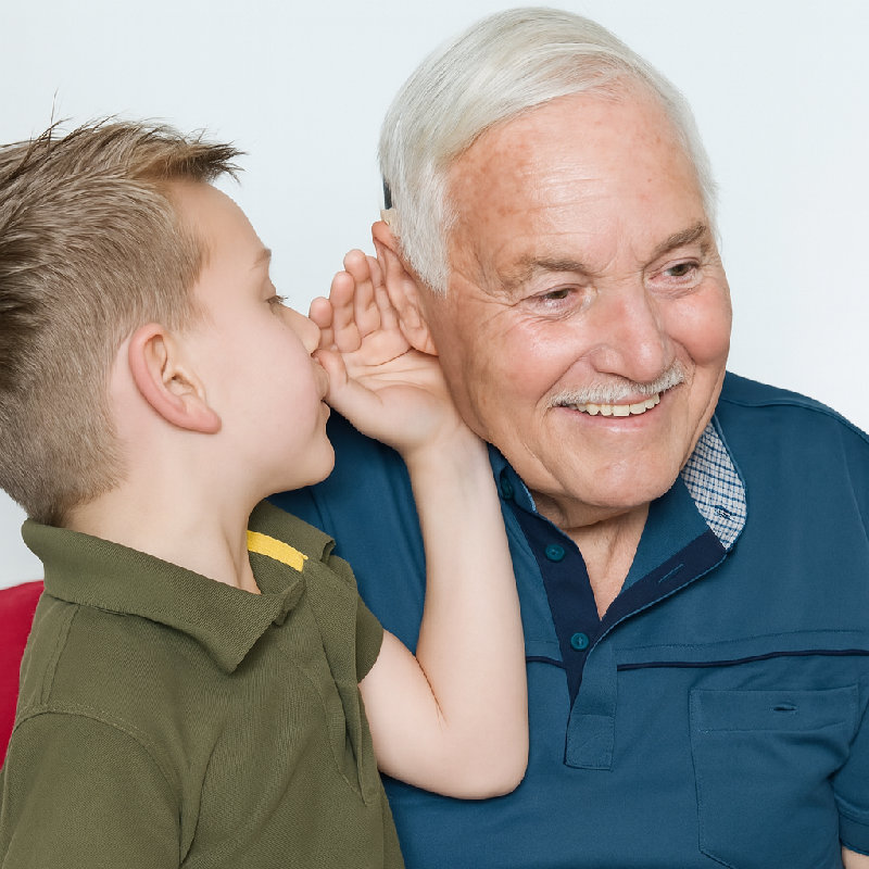 因为老人的听力不好，所以小男孩靠近他的耳朵说话。