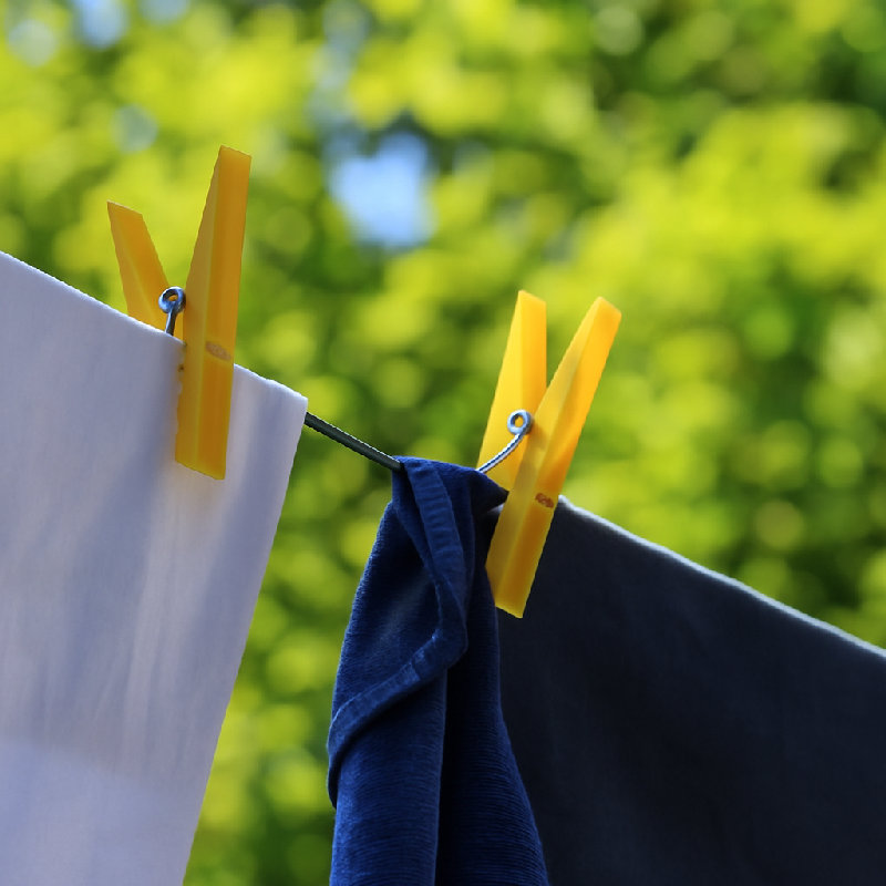 他用衣夹夹住衣服。