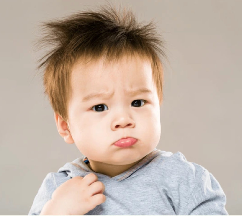 小男孩撅着嘴，因为他不想去睡觉。