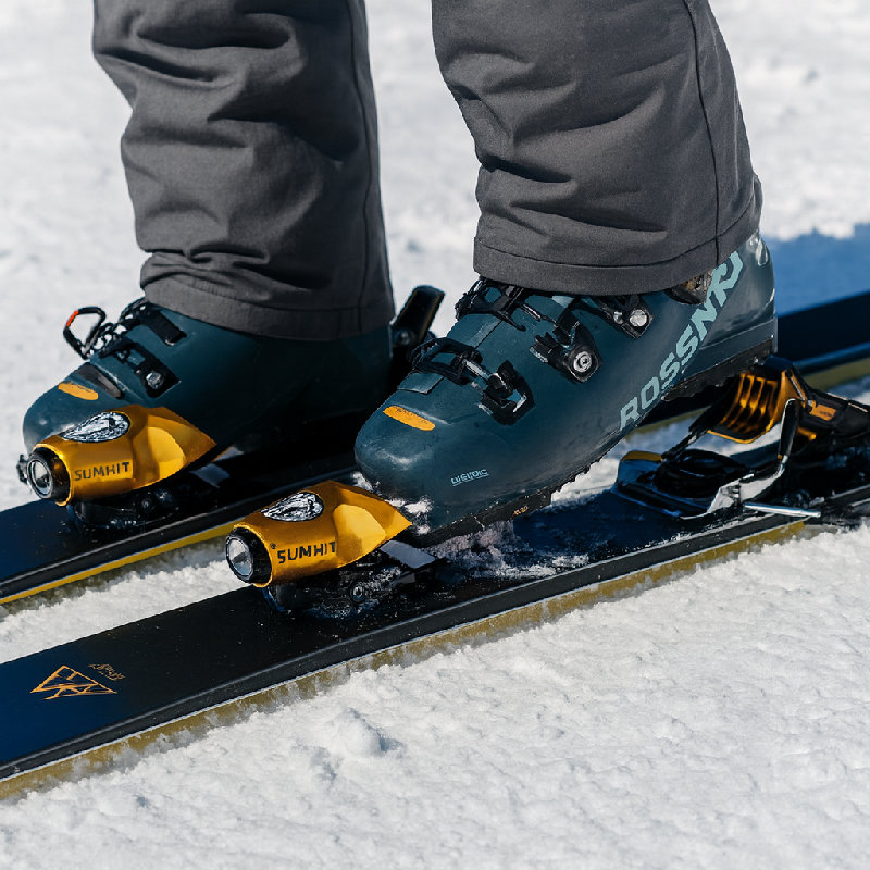 在滑下山之前，他要调整滑雪板固定器。