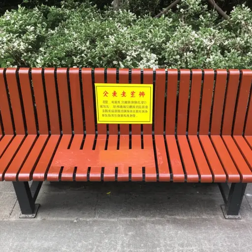 长凳上有个牌子写着'油漆未干！'