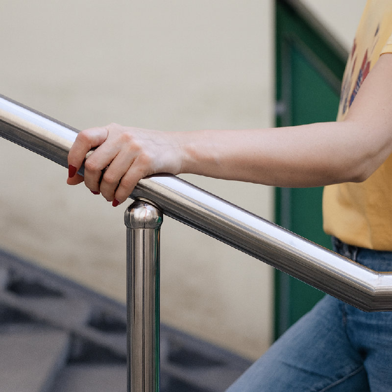 他在爬楼梯时紧紧抓着扶手。