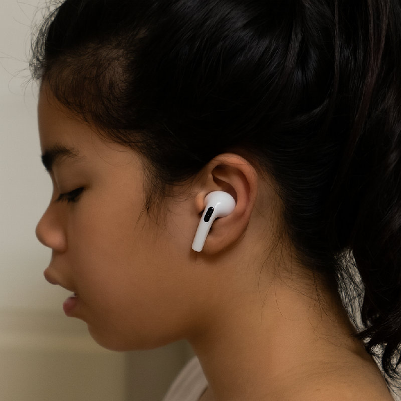 她戴上耳塞练习英语听力，不打扰别人。