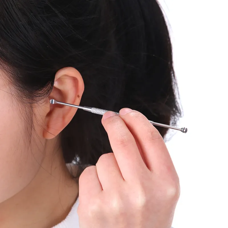 她正在用挖耳勺清理耳朵。