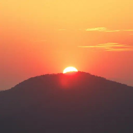 我们看着太阳从山上升起。